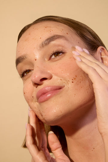 Woman applying Acure Zombie Cell Clarifying mask on her face